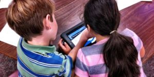 boy and girl looking at a tablet together