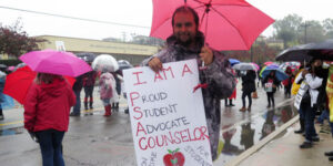 man holding a poster for counselors