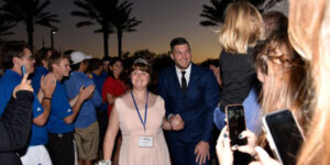 girl with down syndrome wearing dress with Tim Tebow