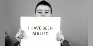 child holding sign bullying