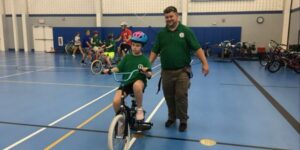 young boy riding a bike inside gymnasium