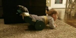 toddler crawling with device supporting back legs