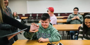 student high-fiving a police officer