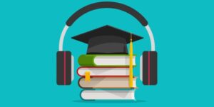 headphones around a graduation cap and books