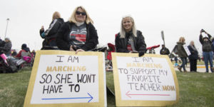 moms holding signs for teacher protest