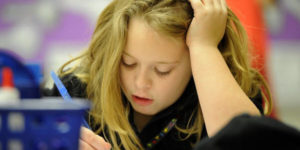 young girl working hard to write