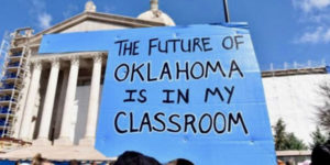 OK teacher protesting walkout sign in front of govt building