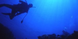 scuba diver in dark blue ocean