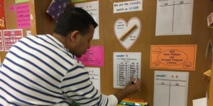 teacher writing something on a personalized cork board